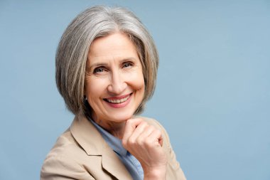Happy senior business woman, manager, financier looking at camera isolated on blue background. Portrait of confident gray haired politician. Successful business, career clipart