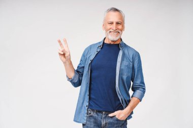Ziyaretçi işareti gösteren, beyaz arka plan stüdyosunda izole edilmiş mutlu, gri sakallı bir adamın portresi. Halk yaşam tarzı konsepti