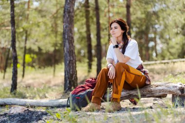 Güzel ormanda yürüyüş yapan aktif ve sağlıklı bir kadın. Yürüyüş sırasında ormanlık alanda dinlenen mutlu, genç bir kadın.