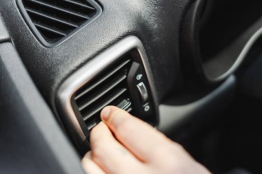 Yolculuk sırasında konfor için arabanın klimasını ayarlıyorum. Kontrol paneli düğmeleri modern teknolojiyi gösteriyor. Temiz hava sürüş deneyimini güçlendirir