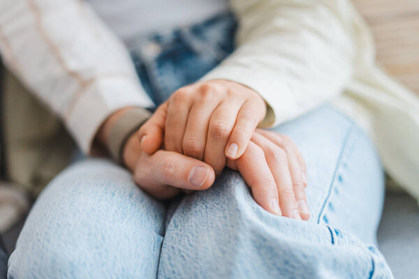 Психолог держит пациента за руку, предлагая комфорт и поддержку во время терапии. Изображение показывает момент связи и сопереживания, подчеркивая психическое здоровье и эмоциональное благополучие