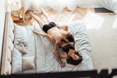 Tutkulu çıplaklık portresi. Genç adam baştan çıkarıcı kadını öpüyor. Yatakta seks yapıyor. Cinsellik, tutku konsepti