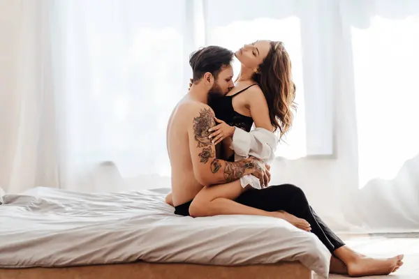 Tutkulu bir genç adamın portresi. Yatak odasında bir kadını kucaklayan ve onu öpen bir dövme. Cinsellik, tutku konsepti