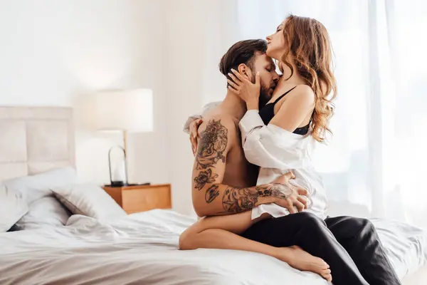 Tutkulu genç bir adamın portresi. Kucaklaşan, kız arkadaşını öpen ve soyan, yatakta oturan. Cinsellik, tutku konsepti