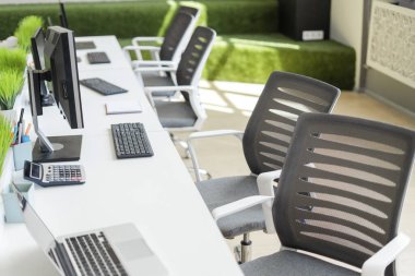 Beyaz masalı, bilgisayarlı ve malzemeli modern ofis alanı. Çalışma ve işbirliği için ideal. Ergonomik sandalyeler ve doğal ışık üretkenlik için rahat bir ortam yaratır