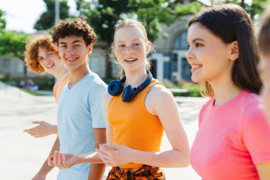 Güzel, pozitif gülümseyen çok ırklı üniversite öğrencileri şehir sokaklarında birlikte yürüyorlar. Şık, otantik gençler buluşuyor, konuşuyor, iletişim kuruyorlar. Arkadaşlık kavramı