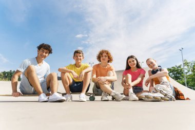 Renkli tişörtler giyen ve kaykay parkında kameraya bakan genç kızların portresi. Yaz zamanı, yaşam tarzı, arkadaşlık konsepti