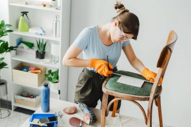 Marangoz atölyesinde restorasyon için eski sandalyeyi ölçüyor. Mobilya restorasyonu, sönük ve sürdürülebilir yaşam konsepti