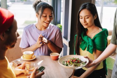 Garson, bir kafede genç bir bayana lezzetli bir yemek servisi yapıyor. Bu sırada arkadaşları sohbet ediyor ve birlikte vakit geçiriyorlar.