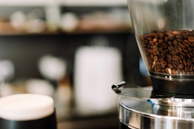 Kapuçinonun tadını çıkarıyorum, latte sanatıyla ve sıcak bir kafede hamur işiyle. Ellerim bardağı tutuyor, davetkar aromayı sergiliyor.