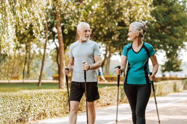 İki son sınıf öğrencisi parkta yürüyorlar, temiz havanın ve birbirlerinin arkadaşlığının tadını çıkarıyorlar. İkisi de gülümsüyor ve iyi vakit geçiriyorlar.