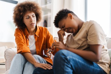 Şefkatli anne üzgün oğlunu rahatlatıyor, aile meselelerini evde tartışıyor. Aile ilişkisi kavramı