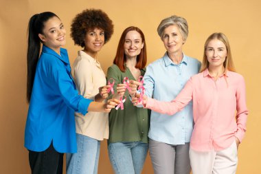 Farklı yaş ve etnik kökenlere sahip beş farklı kadın ellerinde pembe kurdelelerle meme kanseri farkındalığına destek veriyorlar.