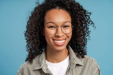 Arka planda izole edilmiş kameraya bakan şık gözlükler takan güzel, gülümseyen Afro-Amerikan kadının portresi. Görüş konsepti