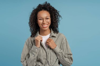 Çekici, gülümseyen, mavi arka planda gözlük takan, gülümseyen Afrikalı Amerikalı kadın. Görüş konsepti