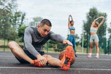 Çekici, aktif Asyalı bir adamın portresi ısınıyor, dışarıda esniyor, antrenman yapıyor. Sağlıklı yaşam tarzı kavramı