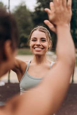 Hareketli, güzel, güler yüzlü, şık bir spor bluzu giyen, el kol hareketi yapan, takım çalışması yapan bir kadın. Birlikte antrenman, spor konsepti
