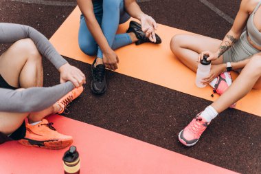 Üst manzara, yoga minderinde oturan sporcular, sokakta, dışarıda dinlenen sporcular. Spor, motivasyon konsepti