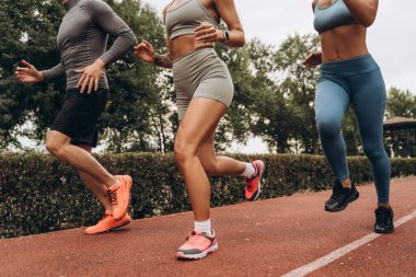 Yakından, aktif, formda spor giyimli, açık havada birlikte koşan bir sporcu. Spor, motivasyon konsepti, reklam