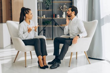 Orta yaşlı, gülümseyen Latin erkek ve kadın portresi, işaret diliyle konuşan modern gündelik kıyafetler giyiyor. İletişim konsepti