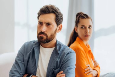 Mutsuz bir çiftin portresi. Evdeki kanepede oturan, kavga eden erkek ve kadın. İlişki kavramı