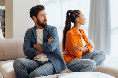 Kızgın mutsuz bir çiftin portresi, evdeki kanepede oturan, kavga eden erkek ve kadın. Küfürlü ilişkiler kavramı