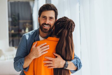 Gülümseme portresi, pozitif, çekici, yakışıklı adam kameraya bakıyor ve güzel bir kadınla sarılıyor. Aşk, zevk konsepti