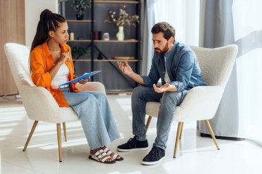 Psikoterapiste giden üzgün bir adam, ilişki sorunları var, modern ofiste birlikte oturuyorlar. Ruh sağlığı kavramı, destek