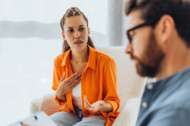 Üzgün, mutsuz, depresyonda olan Latin bir kadın, modern ofiste oturan profesyonel bir doktorla konuşuyor. Sağlık hizmeti kavramı