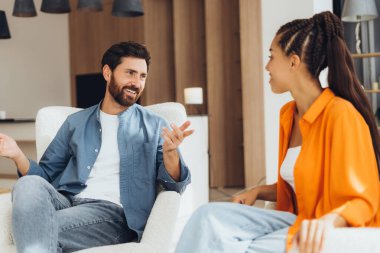 Mutlu, orta yaşlı bir adam ve kadın konuşuyor, rahat bir sandalyede oturup el kol hareketi yapıyorlar. Olumlu arkadaş toplantı yapıyor. İletişim konsepti