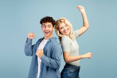 Mutlu, gülümseyen arkadaş portresi, genç kız ve erkek birlikte dans ediyor, kameraya bakıyor, mavi arka planda izole edilmiş eğleniyor. Arkadaşlık kavramı