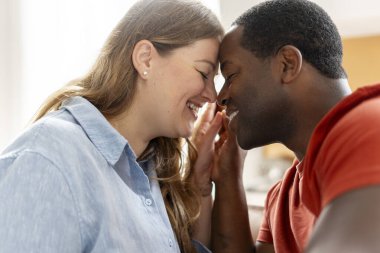 Gülümseyen, orta yaşlı çiftlerin gözlerini kapayıp, evde el ele oturmalarına yakın durun. Aile, ilişkiler konsepti