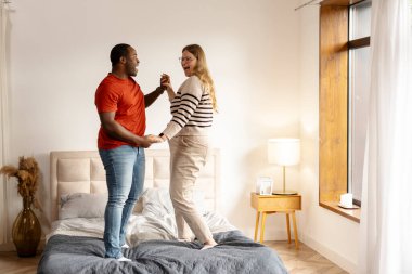 Çok ırklı orta yaşlı bir çiftin portresi dans etmekten, müziğe yönelmekten ve evde ayakta durmaktan zevk alıyor. Aşk, ilişki, romantik konsept