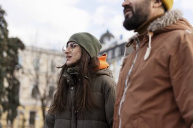 Genç bir çift kışın dışarıda geziyor hafta sonu şehir tatili boyunca gezintilerin tadını çıkarıyor, şehirleri keşfediyor ve kışlık kalın giysiler giyiyor.
