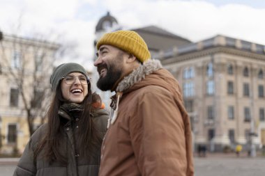 Sıcak kışlık kıyafetler giyen neşeli turistler tarihi bir Avrupa kentini geziyor, kahkahalarını paylaşıyor ve kalıcı anılar yaratıyorlar.