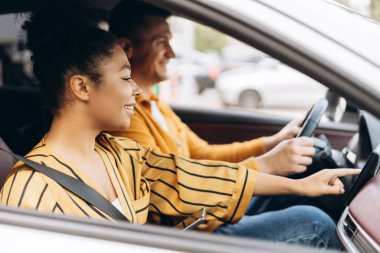 Afrika kökenli Amerikalı bir kadının portresi. Arabanın vitrinine tıklıyor, erkek arkadaşıyla seyahat ediyor. Yaşam tarzı, seyahat kavramı