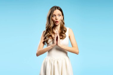 Dua etmek için el ele tutuşan genç bir kadın, yardım dileniyor ya da yalvarıyor, dilek tutuyor, en iyisini umuyor.