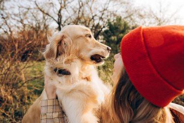 Güneşli bir sonbahar gününde köpeğini tarlada tutan kırmızı bereli genç bir kadın, suç ortaklığının hassas bir anının tadını çıkarıyor.