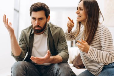 Evdeki bir kanepede oturan genç adam ve kadın hararetli bir tartışmaya giriştiler. İfade vererek ve ilişki sorunları yüzünden hayal kırıklığına uğradıklarını göstererek. Duygular çok yoğun.