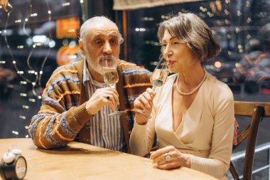 Zarif son sınıf çifti, samimi bir restoranda şampanya kadehleri kaldırıyor. Yeni yıl arifesini romantik atmosfer ve şenlik ışıklarıyla birlikte kutluyorlar. Randevu konsepti