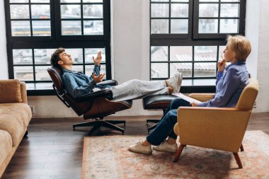 Koltuğa uzanmış genç bir çocuğun portresi psikologla ofisteki terapi seansındaki sorunu hakkında konuşuyor. Ruh sağlığı konsepti