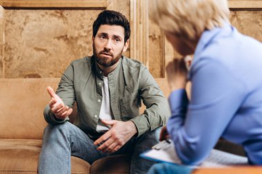 Profesyonel psikoterapist kabinesinde konuşan üzgün sakallı adam. Bir psikoloğun yardımı