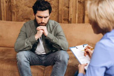 Sakallı adamın portresi muayeneyi ziyaret ediyor, ofisteki kadın psikoterapistle sohbet ediyor. Psikolojik destek kavramı