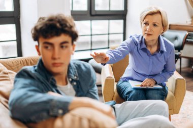 Kadın psikoloğun portresi, danışman ofiste genç bir çocukla konuşuyor. Psikolojik destek kavramı