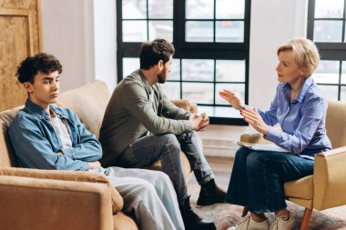 Kadın psikoterapistin portresi. Babası ve ergen oğlu için akıl sağlığı hakkında konuşuyor. Aile sorunları, gençlik sorunları, terapist, tavsiye, yardım kavramı