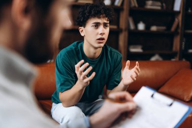 Ofiste terapi seansı sırasında profesyonel erkek psikanalistle genç bir çocuğun portresi. Danışmanlık terapisi. Psikoloji tedavisi