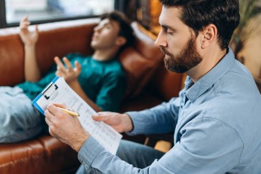 Kanepede yatan genç bir çocuğun portresi erkek psikanalistten teşhis bekliyor. Psikoterapi hizmetleri, ruhsal sağlık profesyonel konsepti