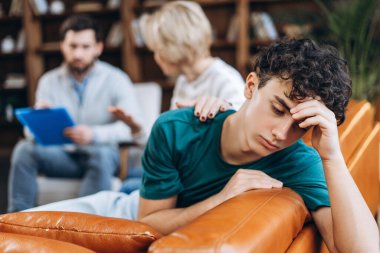 Annesinin profesyonel psikoterapistle konuşmasını bekleyen stresli genç bir çocuğun portresi. Danışmanlık terapisi. Psikoloji tedavisi