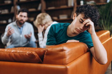 Erkek psikolog olarak dinleyerek annesine tavsiyelerde bulunan stresli genç bir çocuğun portresi. Danışmanlık terapisi. Psikoloji tedavisi