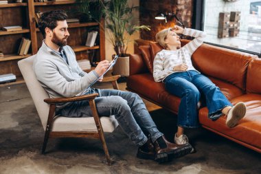 Profesyonel erkek psikoloğun portresi notlar yazıyor, modern ofisteki kadın müşteriyle konuşuyor. Psikolojik destek kavramı